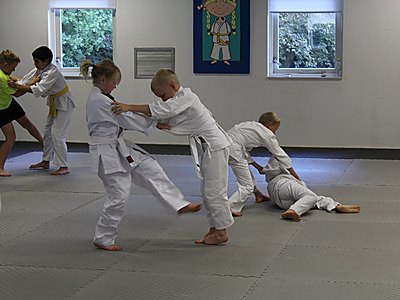 Judoles voor kinderen in Apeldoorn: jeugdleden oefenen een worp in judopak
